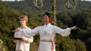 woman in white dress welcomes revelers