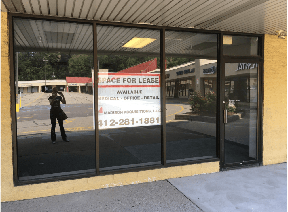 empty storefront with 'for rent' sign