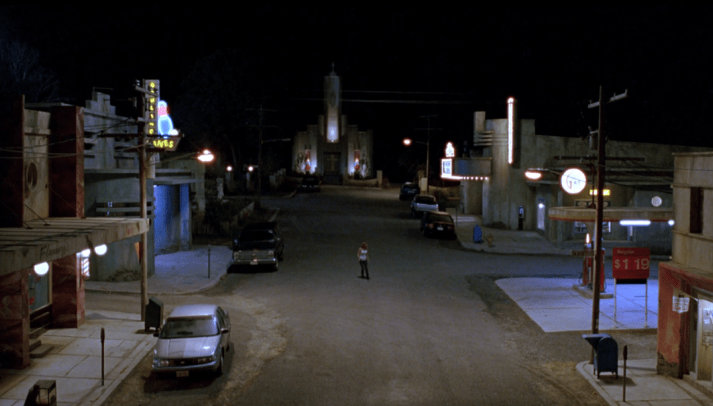 a man stands alone in the center of an empty street